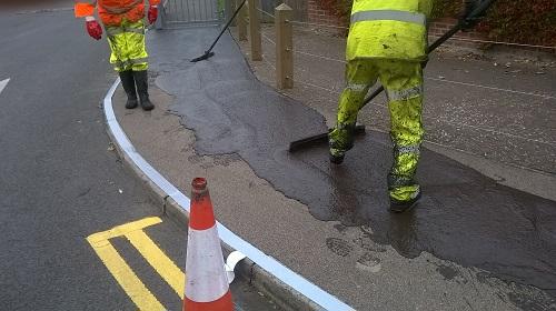 Highway engineers brushing a pavement to give it a textured finish
