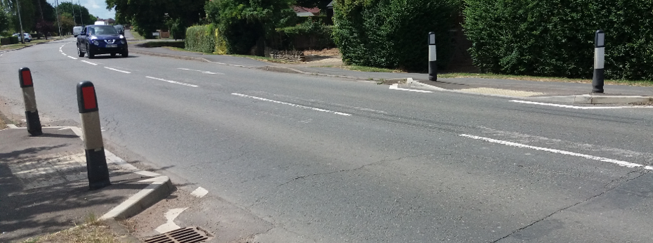 Road with kerbside build outs and metal bollards either side